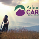 A woman in a field with crutches looks toward mountains under a dramatic sky. Arkansas CARES, a Methodist Family Health program logo appears in the top right corner.